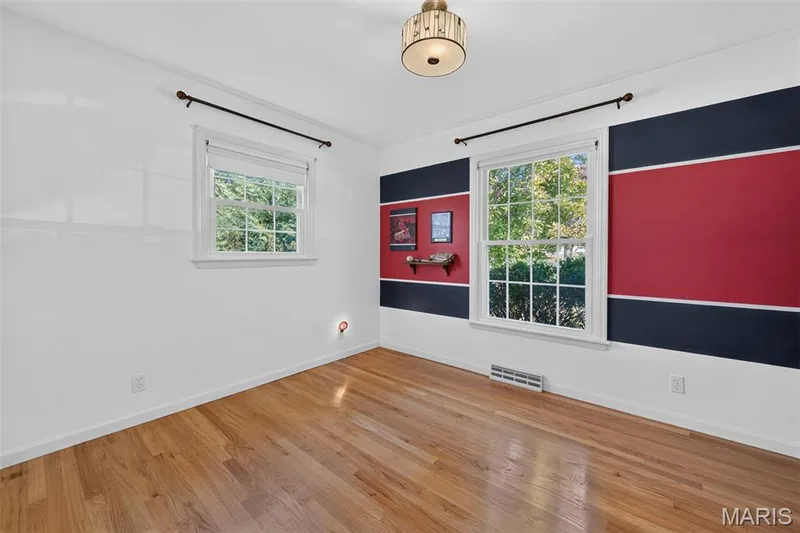 The same bedroom unstaged, complete with its fun Cardinals-themed walls and memorabilia. — 2913 Cypress Drive, St Charles, MO 63301