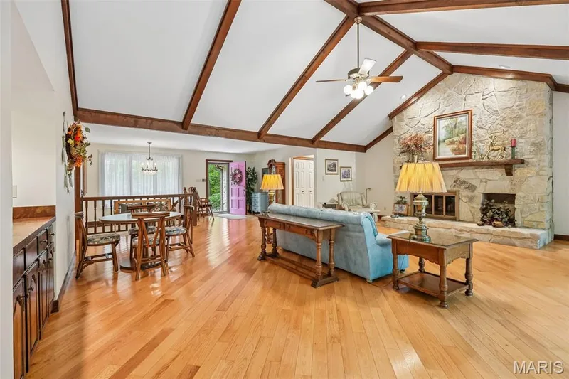 Great room featuring vaulted ceiling, stone fireplace and wood floors — 2260 Ridgley Woods Drive, Chesterfield, MO 63005