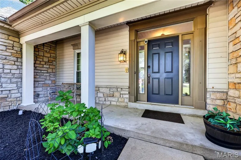Covered porch entry featuring stone and siding exterior — 17711 Birch Leaf Court, Chesterfield, MO 63005