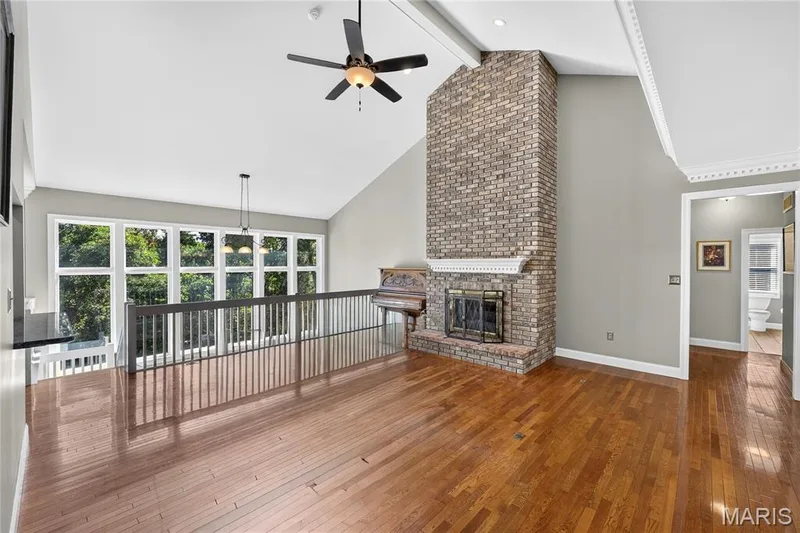 Vaulted ceilings, a full-height brick fireplace, wood-finish flooring, and crown molding — 17711 Birch Leaf Court, Chesterfield, MO 63005