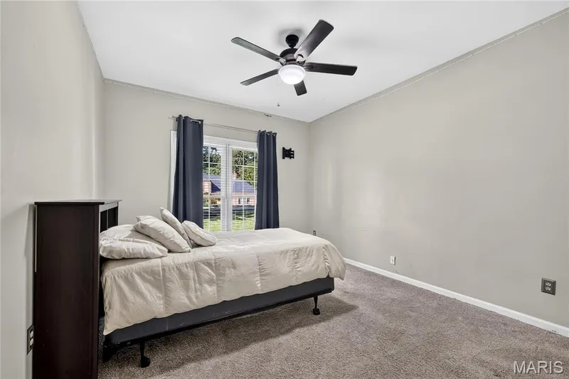 Carpeted flooring, window with exterior landscape, and ceiling fan with integrated lighting — 17711 Birch Leaf Court, Chesterfield, MO 63005