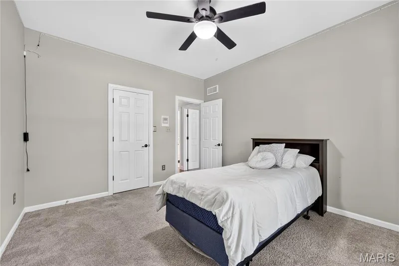 Vaulted ceiling with a ceiling fan, neutral wall tones, and plush carpeting — 17711 Birch Leaf Court, Chesterfield, MO 63005