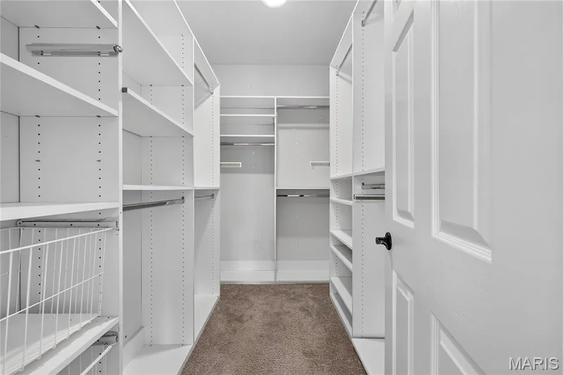 White built-in shelving, integrated hanging rods, and a white wire basket drawer system — 17711 Birch Leaf Court, Chesterfield, MO 63005