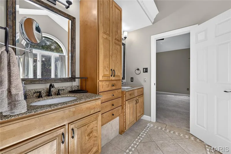 Dual wood-finish vanities with speckled countertops and undermount sinks — 17711 Birch Leaf Court, Chesterfield, MO 63005