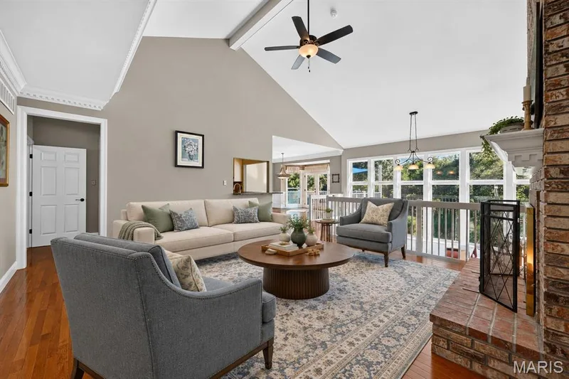 Vaulted ceilings, brick fireplace, wood-finish flooring, extensive natural light from floor-to-ceiling windows, and crown molding — 17711 Birch Leaf Court, Chesterfield, MO 63005