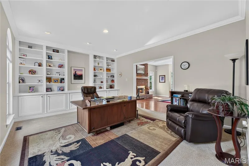 Living room/home office has a wall of built-ins for storage and display. — 947 Crown Pointe Estates Drive, Wildwood, MO 63021