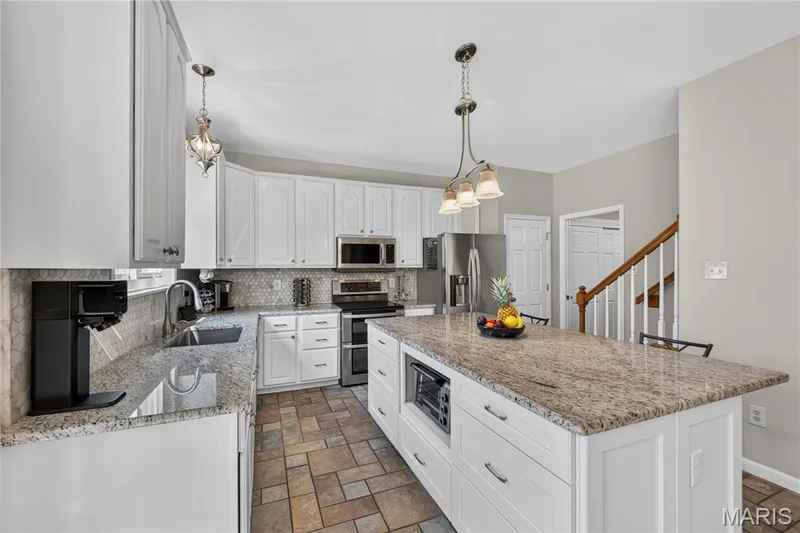 Kitchen as white cabinetry, granite counters, stainless appliances. — 947 Crown Pointe Estates Drive, Wildwood, MO 63021