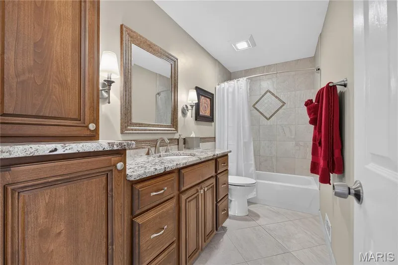Upper level full bath features gorgeous cabinetry with granite counters, tiled shower and flooring — 947 Crown Pointe Estates Drive, Wildwood, MO 63021