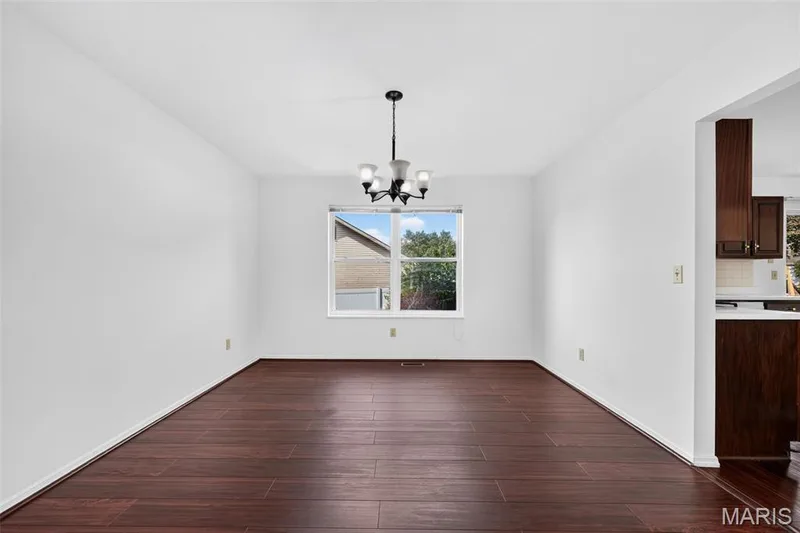 Wood-finish flooring with a satin finish, white walls, and a black chandelier — 39 Green Pines Circle, St Peters, MO 63376