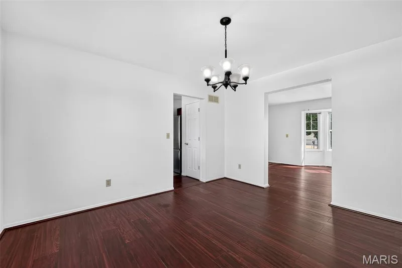 Wood-finish flooring throughout, bright white walls, and a contemporary five-light chandelier — 39 Green Pines Circle, St Peters, MO 63376