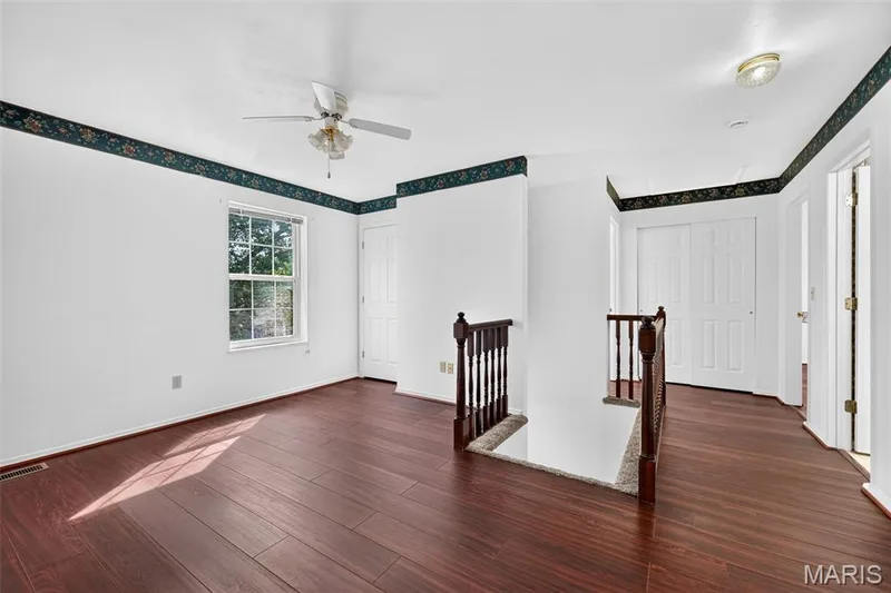 Wood-finish flooring throughout, white walls, ceiling fan, and white paneled doors — 39 Green Pines Circle, St Peters, MO 63376