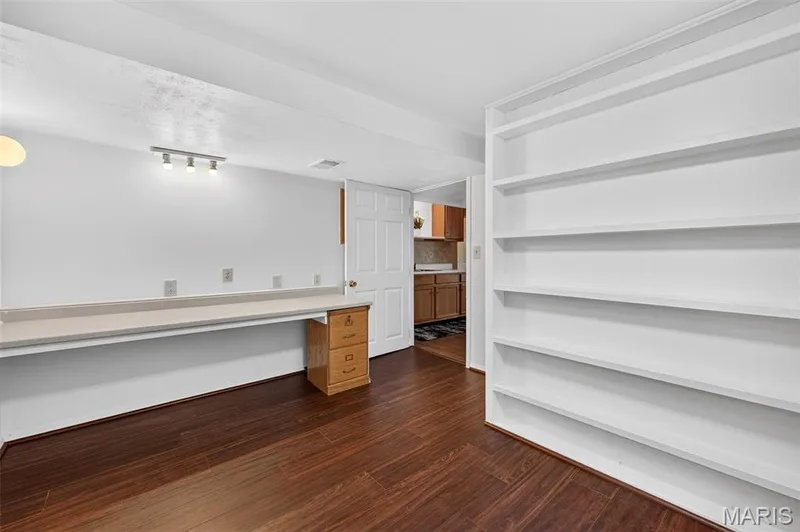 Built-in wall shelving, integrated desk surface, wood-finish flooring, and recessed lighting — 39 Green Pines Circle, St Peters, MO 63376