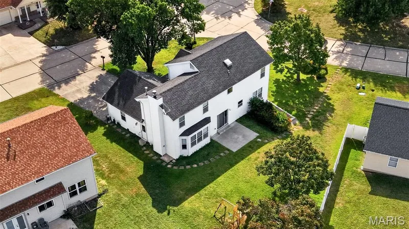 White exterior with bay window, rear patio, and mature trees — 39 Green Pines Circle, St Peters, MO 63376