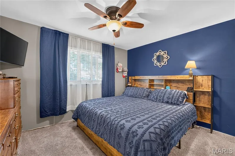 Spacious primary bedroom with ceiling fan and large window overlooking backyard. — 2910 Nantwich Lane, St Charles, MO 63301