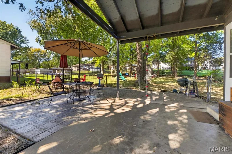 Attached carport with side-entry access to the home, plus a stamped patio overlooking the large fenced backyard. — 2910 Nantwich Lane, St Charles, MO 63301