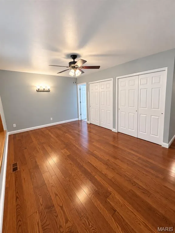 Hardwood flooring, two sets of bi-fold closet doors, ceiling fan with integrated lighting, and a wall-mounted light fixture — 3 Fairfax Drive, St Peters, MO 63376