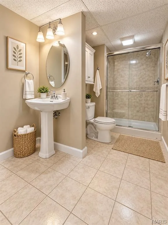 Downstairs pedastal sink with oval mirror, tiled flooring, built-in shower with sliding glass door, recessed lighting, and wall-mounted storage cabinetry i — 3 Fairfax Drive, St Peters, MO 63376