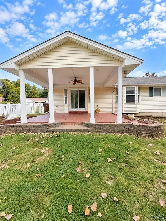 Expansive covered patio with support columns and a ceiling fan — 3 Fairfax Drive, St Peters, MO 63376