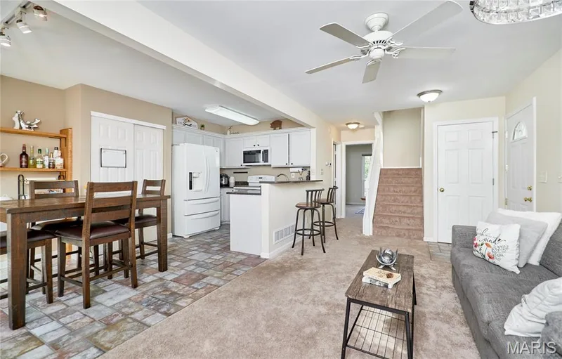 Kitchen featuring white cabinetry and appliances, tile flooring, and a breakfast bar — 16500 Victoria Crossing Drive, Wildwood, MO 63040