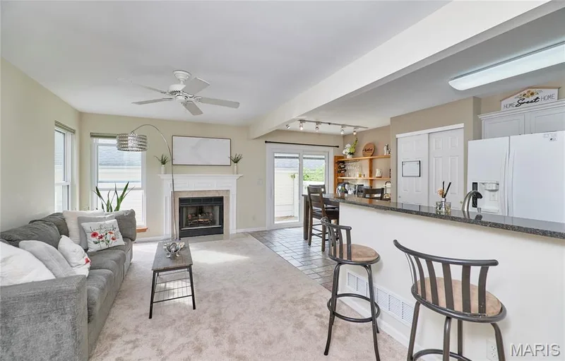Living area with a built-in fireplace, white mantel, and ceiling fan — 16500 Victoria Crossing Drive, Wildwood, MO 63040