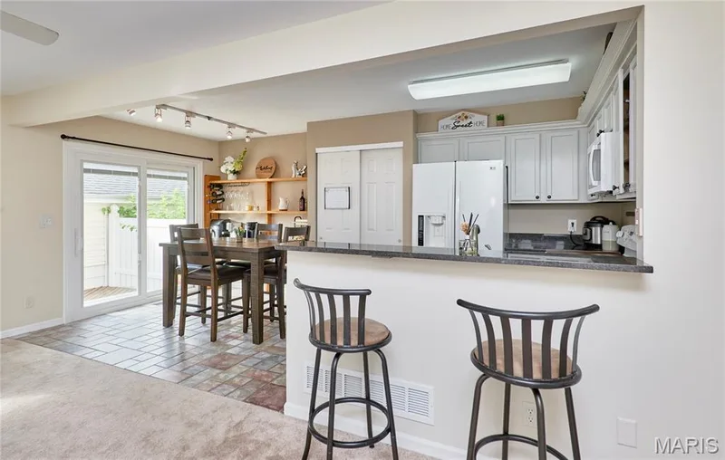 Kitchen pass-through with a stone-finish countertop — 16500 Victoria Crossing Drive, Wildwood, MO 63040