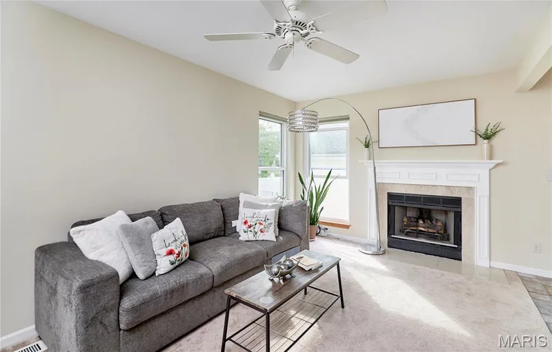 Built-in fireplace with a stone surround and white mantel, overhead ceiling fan, and light-toned wall color — 16500 Victoria Crossing Drive, Wildwood, MO 63040