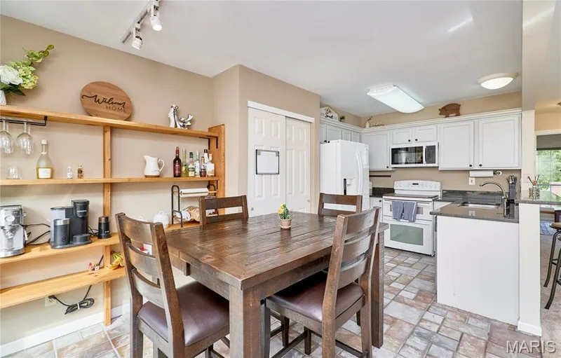 Kitchen featuring white cabinetry, built-in microwave, and stone-look tile flooring — 16500 Victoria Crossing Drive, Wildwood, MO 63040