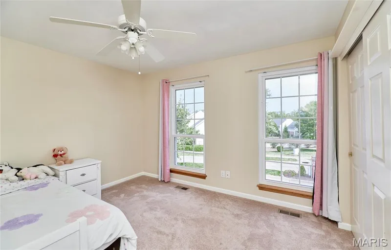 Room with two windows, carpet flooring, and a ceiling fan with integrated lighting — 16500 Victoria Crossing Drive, Wildwood, MO 63040