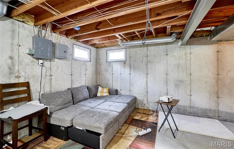 Basement space featuring exposed wood joists, concrete walls, and two visible windows — 16500 Victoria Crossing Drive, Wildwood, MO 63040