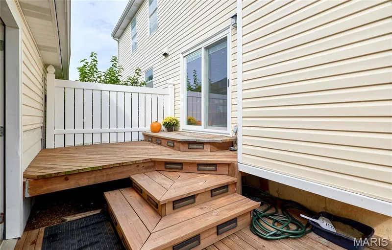 Wood deck with multi-level steps, integrated step lighting, and white privacy fencing — 16500 Victoria Crossing Drive, Wildwood, MO 63040