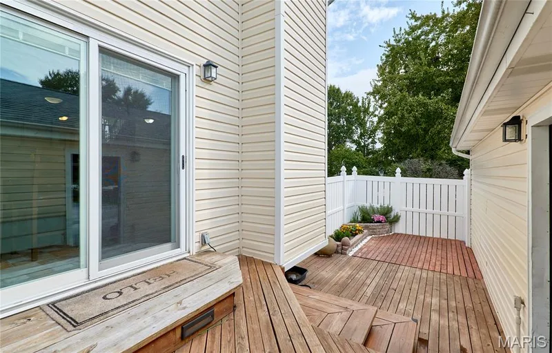 Wood-finish deck with multiple levels, white privacy fencing, and a built-in garden bed — 16500 Victoria Crossing Drive, Wildwood, MO 63040