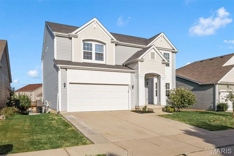 Two-story residence featuring light gray siding with white trim accents and a dual-car garage — 543 Country Chase Drive, Lake St. Louis, MO 63367