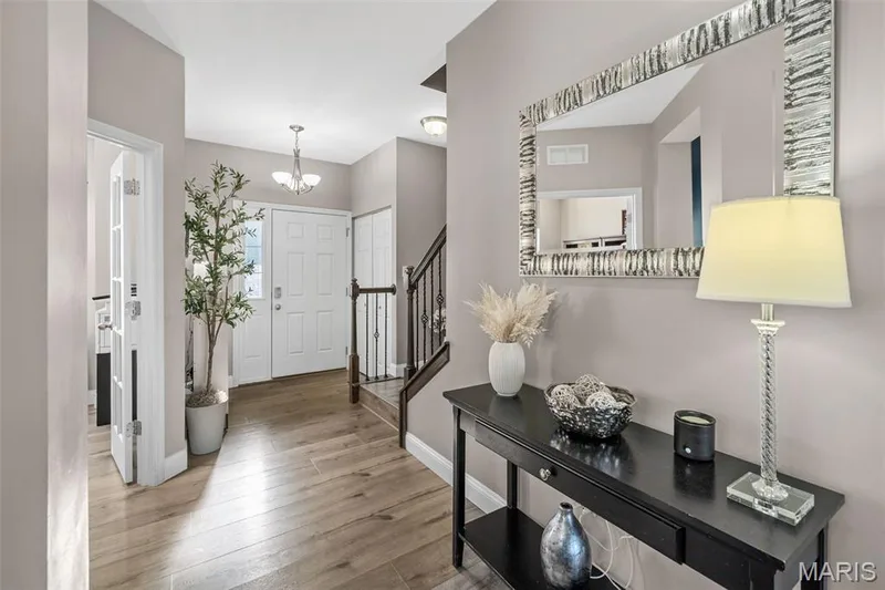 Wood-finish flooring throughout, with a white paneled entry door and a white paneled closet door — 543 Country Chase Drive, Lake St. Louis, MO 63367