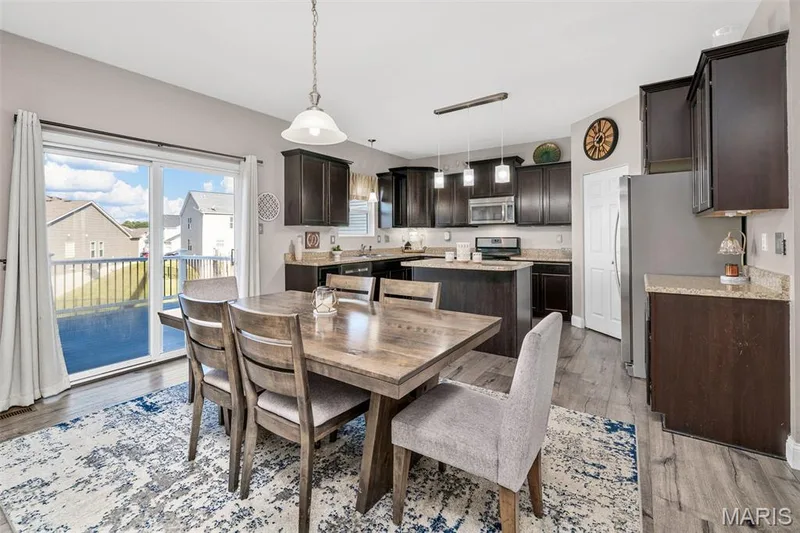 Kitchen featuring wood-finish flooring, dark wood cabinetry, stainless steel appliances, and light-toned countertops — 543 Country Chase Drive, Lake St. Louis, MO 63367