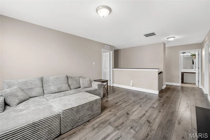 Wood-finish flooring throughout, neutral wall paint, white baseboards, and ceiling-mounted light fixtures — 543 Country Chase Drive, Lake St. Louis, MO 63367