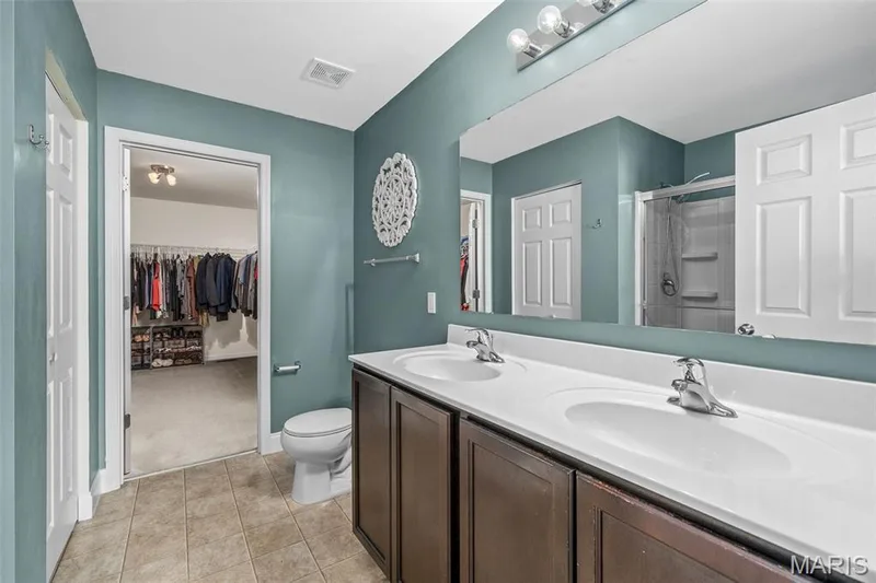 Dual vanity with integrated sinks, chrome fixtures, and dark wood-finish cabinetry — 543 Country Chase Drive, Lake St. Louis, MO 63367