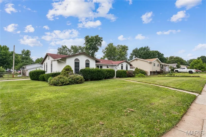 Expansive front lawn with mature landscaping, architectural arched windows, and a classic exterior finish — 2801 Droste Road, St Charles, MO 63301