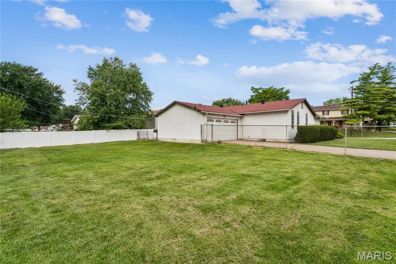 Expansive grassy area with a partial privacy fence and chain link fencing — 2801 Droste Road, St Charles, MO 63301