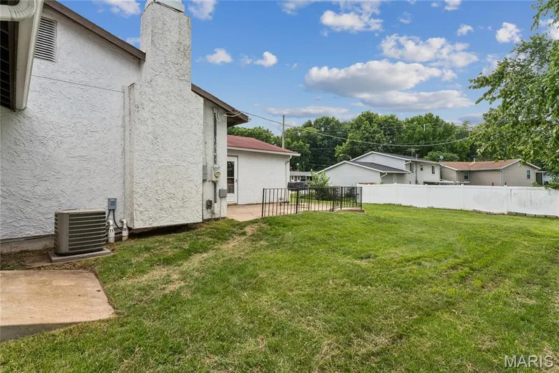 Expansive grass yard with a white privacy fence and concrete patio — 2801 Droste Road, St Charles, MO 63301
