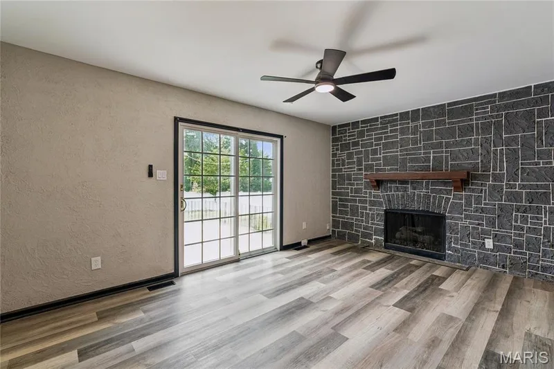 Stone accent wall with a fireplace and wood mantel — 2801 Droste Road, St Charles, MO 63301