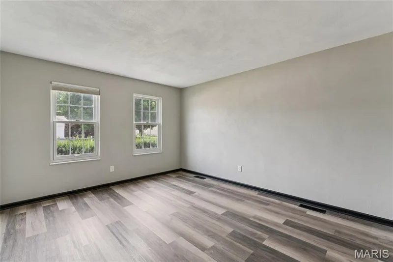 Wood-finish flooring, light grey wall paint, and two windows with white frames — 2801 Droste Road, St Charles, MO 63301
