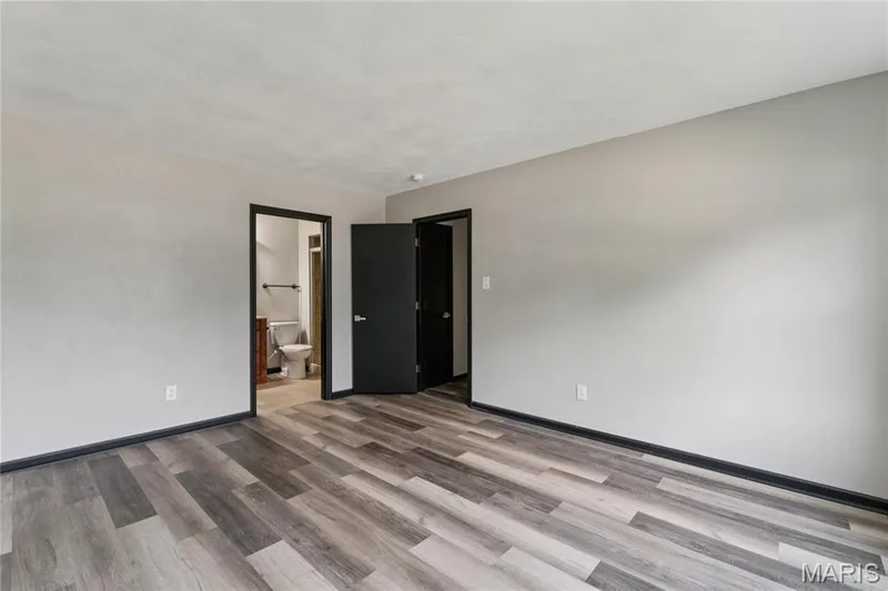 Wood-finish flooring, light gray walls, dark trim, and solid dark doors — 2801 Droste Road, St Charles, MO 63301