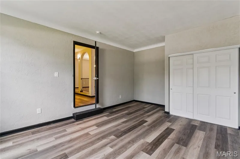 Wood-finish flooring, textured walls, and a multi-panel sliding closet door — 2801 Droste Road, St Charles, MO 63301