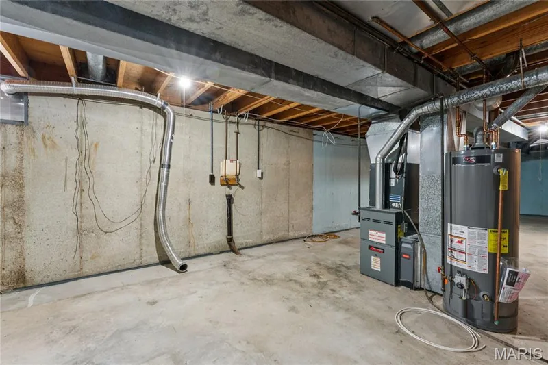 Unfinished basement with concrete flooring, exposed ceiling beams, 2 sump pumps and drain around perimeter — 2801 Droste Road, St Charles, MO 63301