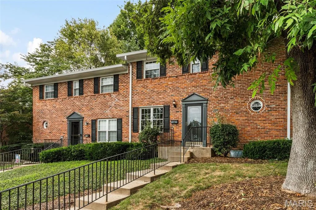 Classic brick exterior construction featuring black shutters, a gabled entry, and a round accent window — 1192 Cantina Drive, Chesterfield, MO 63141