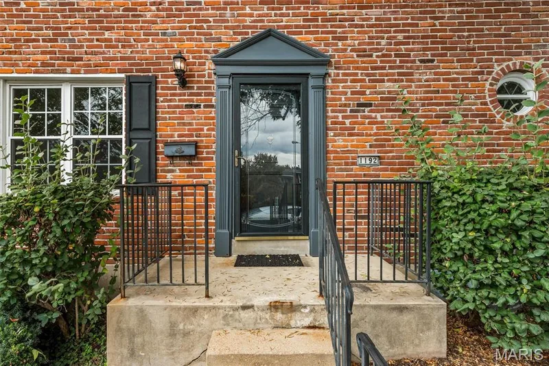 Prominent front entry, black framed storm door, and wrought iron railings — 1192 Cantina Drive, Chesterfield, MO 63141