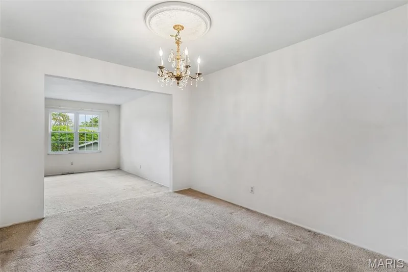 Large dining room features recessed opening, chandelier with ceiling medallion, and neutral carpeting — 1192 Cantina Drive, Chesterfield, MO 63141