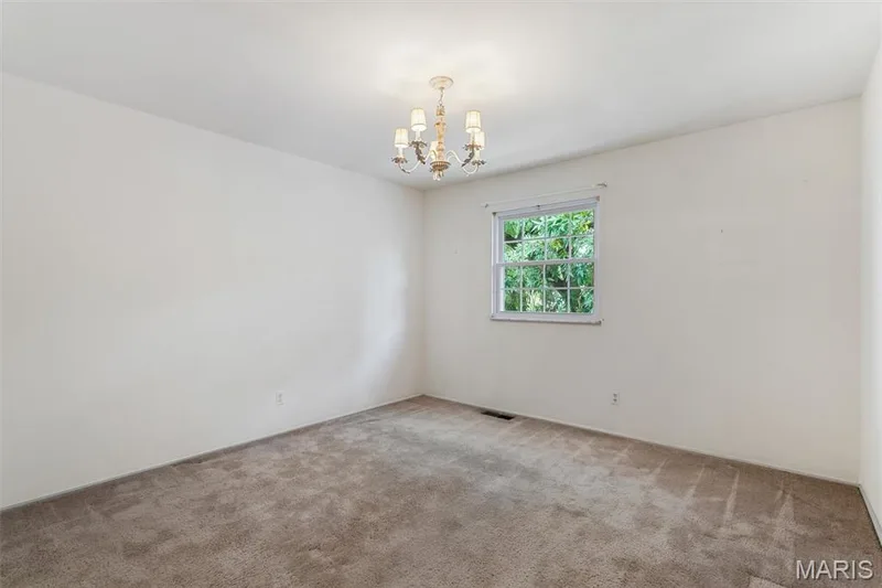 Wall-to-wall carpeting, single window, and a ceiling-mounted chandelier — 1192 Cantina Drive, Chesterfield, MO 63141