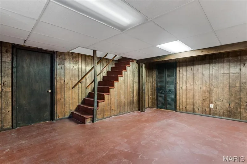 Recreation room in lower level with wood-paneled walls, a drop ceiling and integrated lighting — 1192 Cantina Drive, Chesterfield, MO 63141