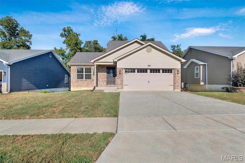 Brick and siding exterior featuring an attached two-car garage, concrete driveway, and front walkway — 56 Huntleigh Park Court, Wentzville, MO 63385